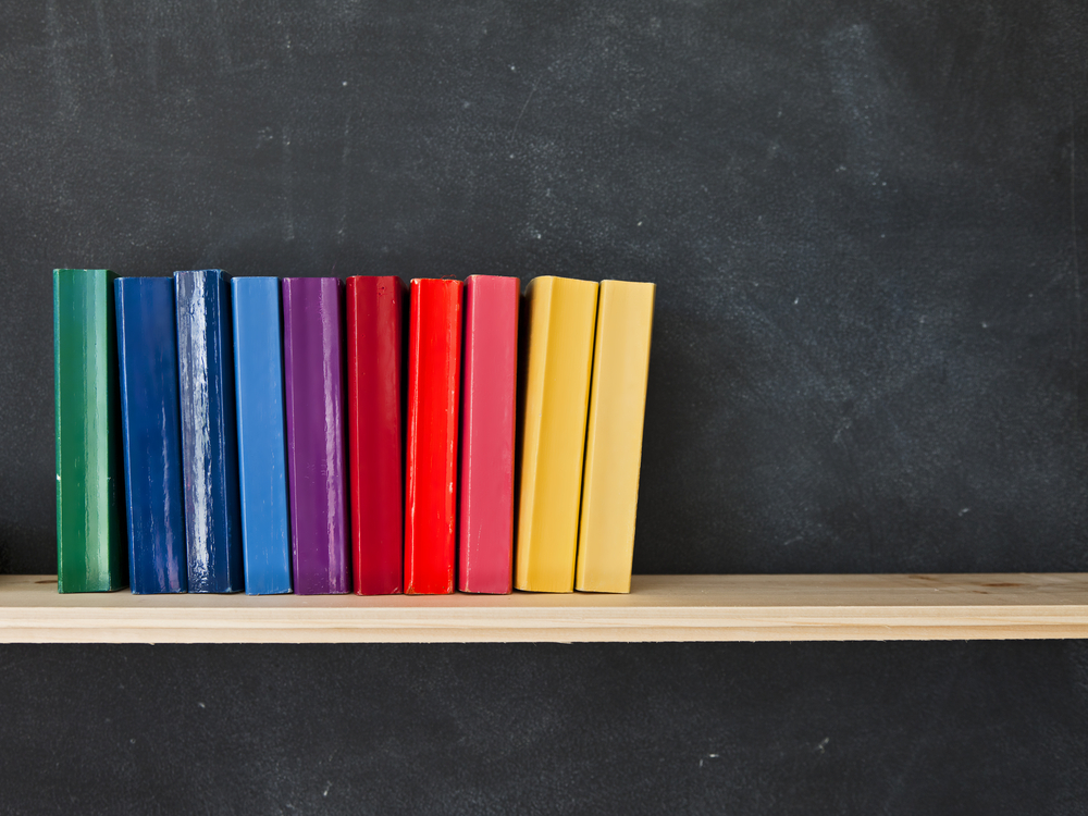 Rainbow-colored books stacked alongside one another.